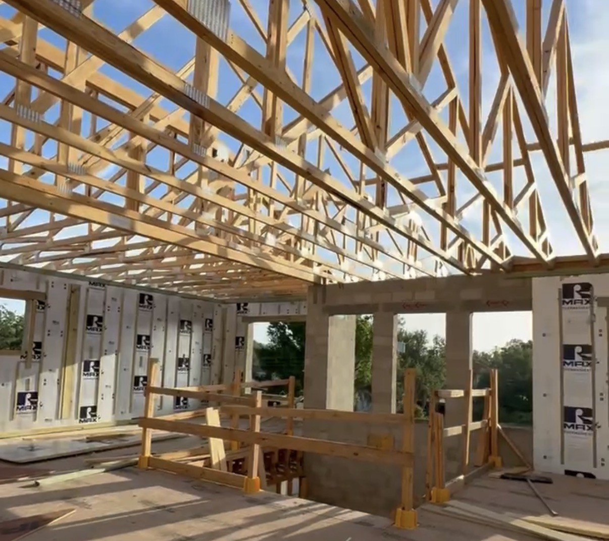 Custom home under construction with wooden roof trusses and framing
