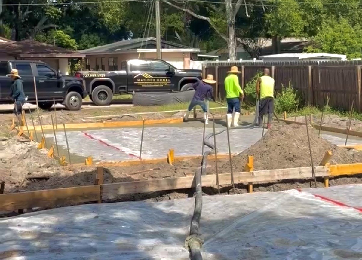 Matlock Custom Homes crew pouring a concrete foundation slab on a Florida job site